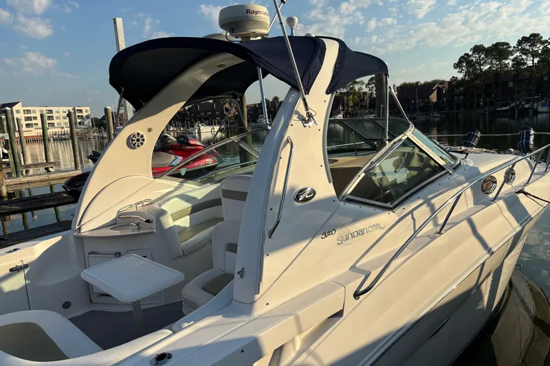 The Image of 2006 Sea Ray Sundancer 320 docked, featuring sleek design and spacious deck under a clear sky. - 1