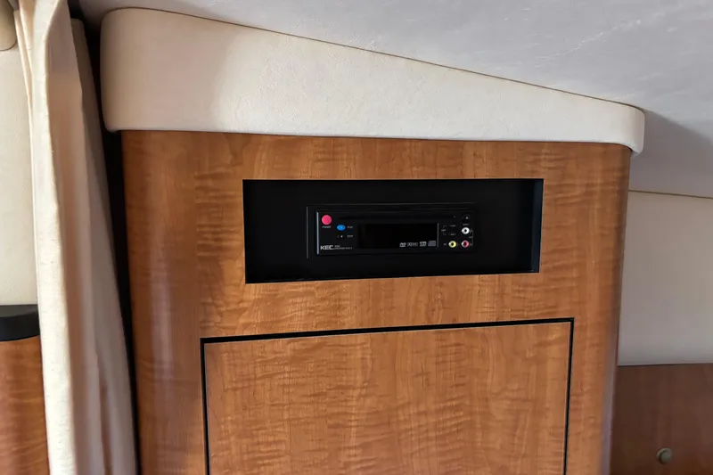 Slide: The Image of 2006 Sea Ray Sundancer 320 interior with built-in media player on wooden panel. - 12