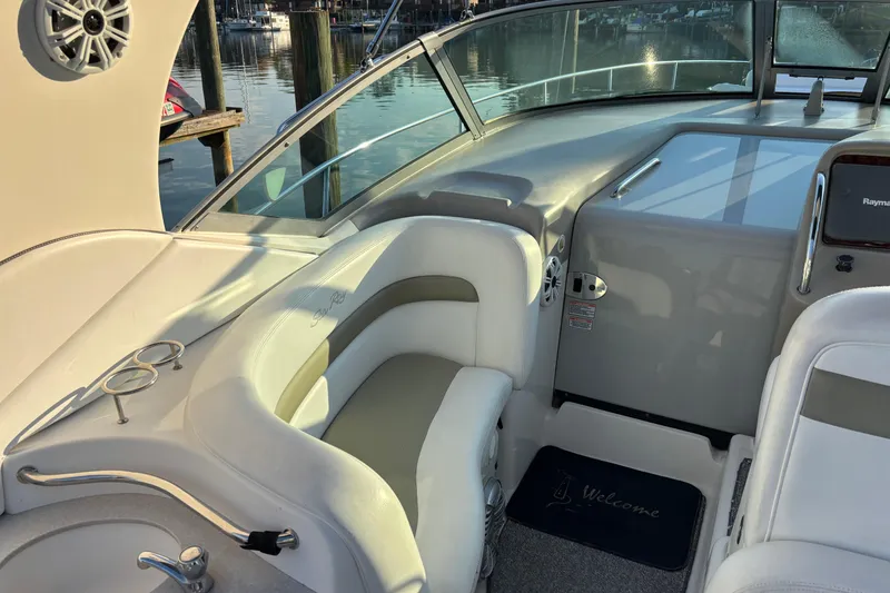 Slide: The Image of 2006 Sea Ray Sundancer 320 cockpit with white seating and marina view. - 8