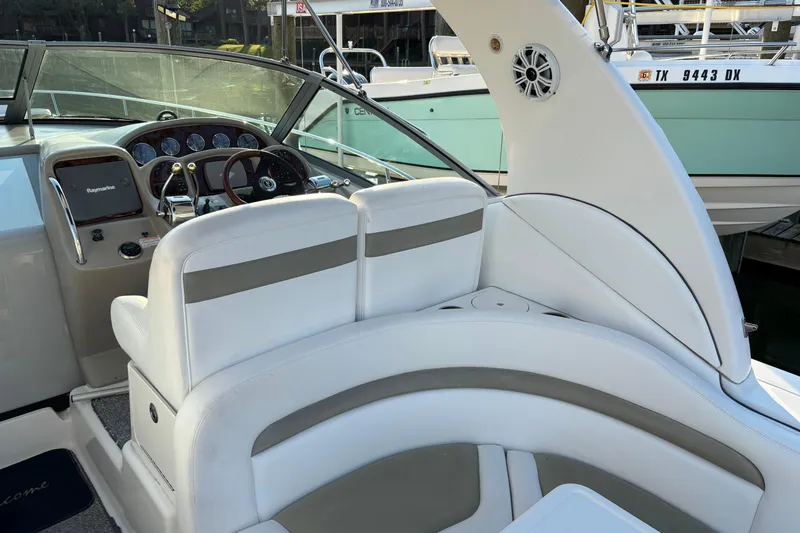 Slide: The Image of 2006 Sea Ray Sundancer 320 cockpit with white seating and steering console. - 9