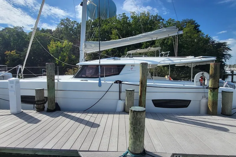 The Image of 2018 Fountaine Pajot Helia 44 catamaran docked, surrounded by lush greenery and clear skies. - 0