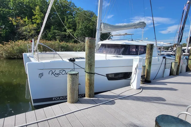 Slide: The Image of 2018 Fountaine Pajot Helia 44 catamaran docked at marina, surrounded by lush greenery. - 23