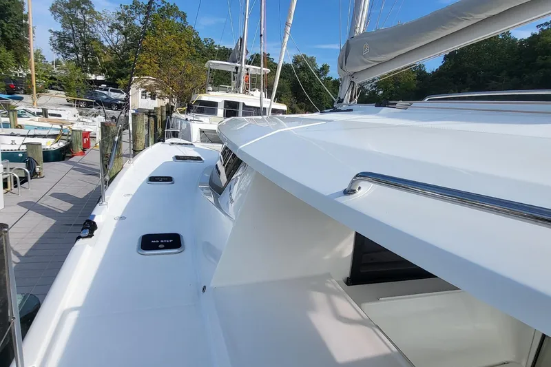 Slide: The Image of 2018 Fountaine Pajot Helia 44 catamaran docked, showcasing sleek white deck and rigging. - 25