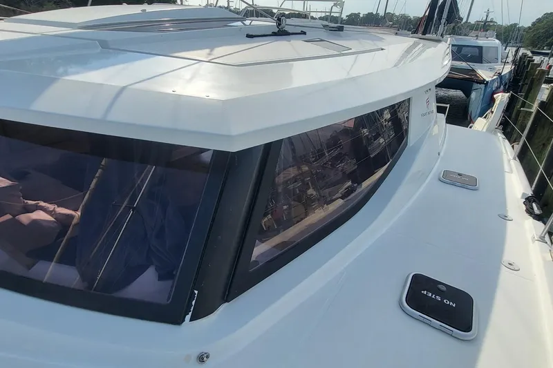 Slide: The Image of 2018 Fountaine Pajot Helia 44 catamaran, docked, showcasing sleek design and spacious deck. - 28