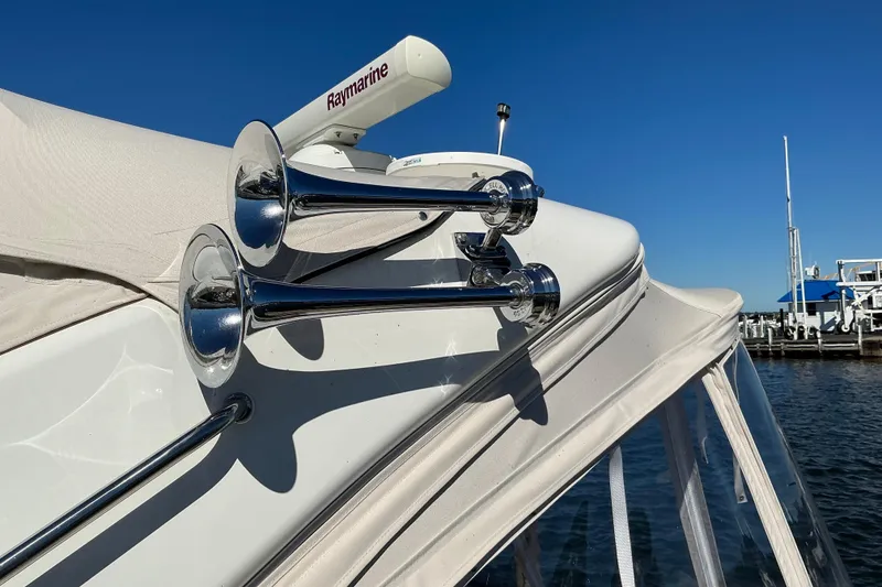Slide: The Image of 2003 Regal Commodore 4260 yacht with chrome horns and Raymarine equipment at a marina. - 13