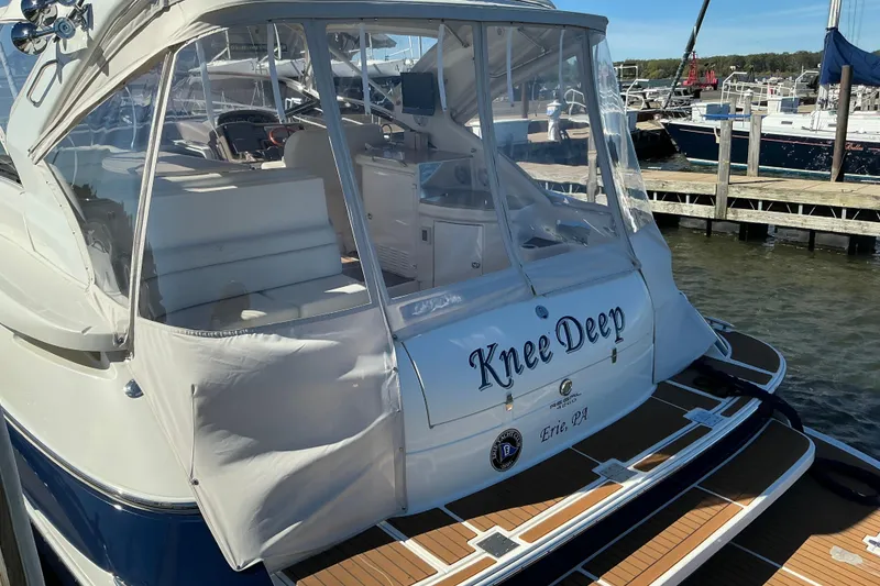 Slide: The Image of 2003 Regal Commodore 4260 yacht named "Knee Deep" docked at a marina. - 14