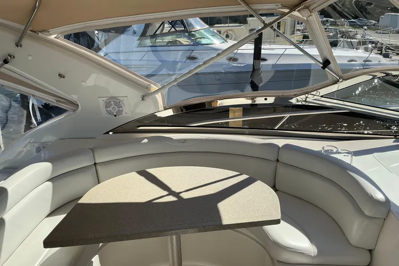 Slide: The Image of 2003 Regal Commodore 4260 yacht interior with curved seating and table, docked at marina. - 17