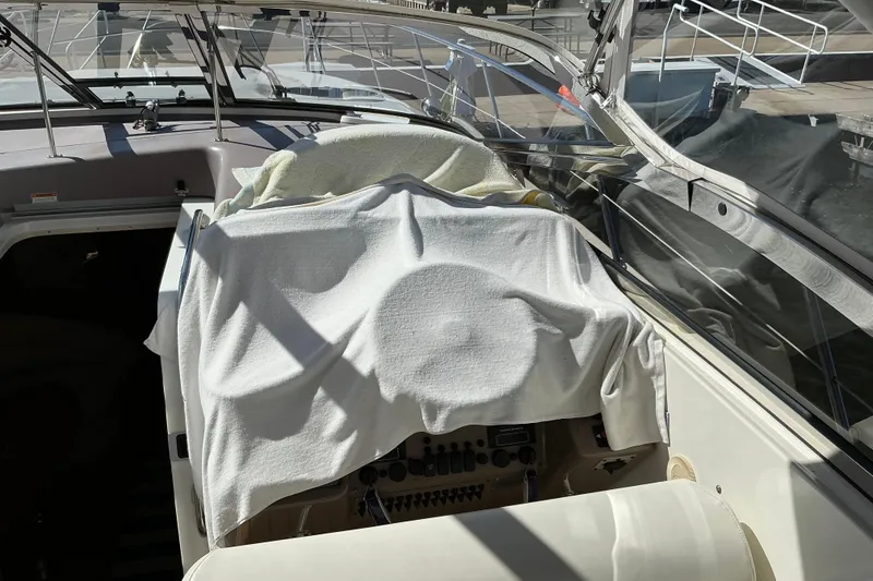 Slide: The Image of 2003 Regal Commodore 4260 boat interior with covered dashboard and seating area. - 30