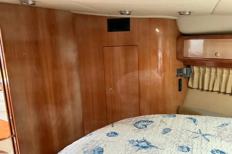 Slide: The Image of Interior of 2003 Regal Commodore 4260 yacht with wood paneling and nautical-themed bedding. - 40