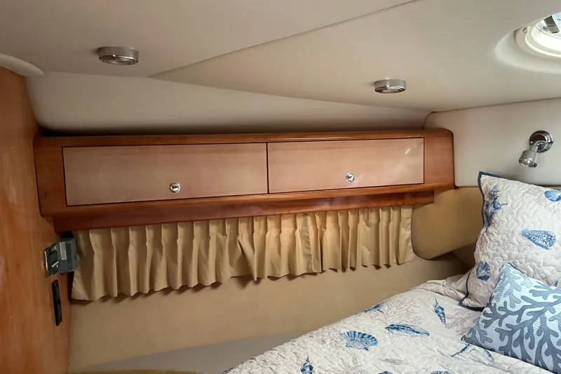 Slide: The Image of 2003 Regal Commodore 4260 cabin interior with wooden cabinets and nautical-themed bedding. - 41