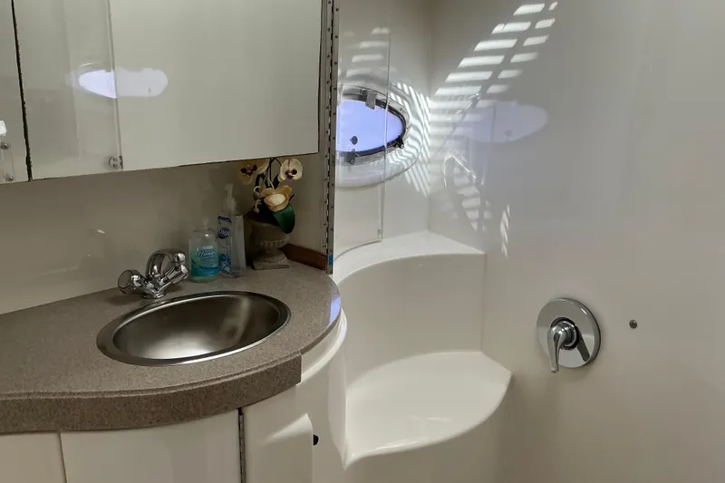 Slide: The Image of 2003 Regal Commodore 4260 yacht bathroom with sink, faucet, and porthole window. - 43
