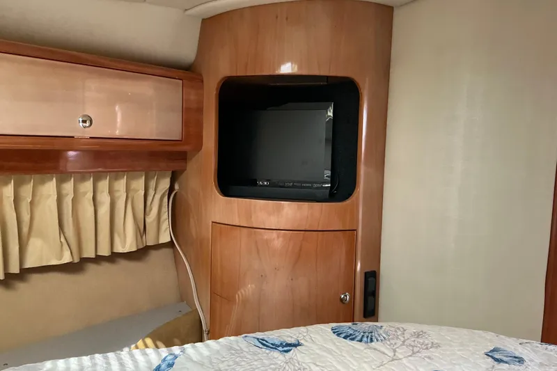 Slide: The Image of 2003 Regal Commodore 4260 cabin interior with TV and wooden cabinetry. - 44
