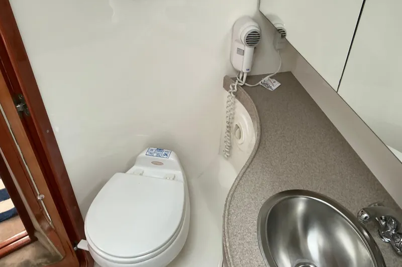 Slide: The Image of 2003 Regal Commodore 4260 bathroom with toilet, sink, and wall-mounted hairdryer. - 47