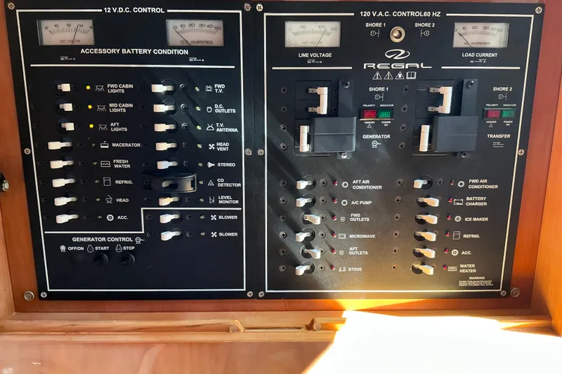 Slide: The Image of Electrical control panel of a 2003 Regal Commodore 4260 boat, featuring switches and gauges. - 54