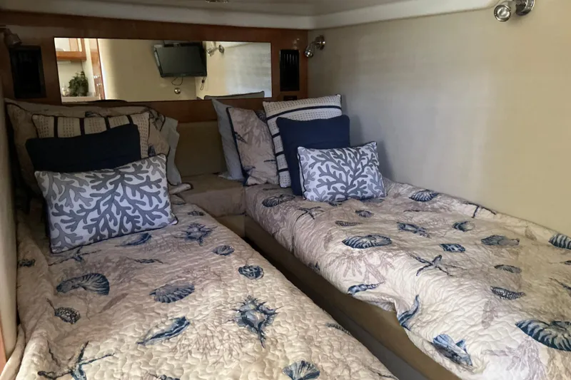 Slide: The Image of 2003 Regal Commodore 4260 cabin with twin beds and nautical-themed bedding. - 57