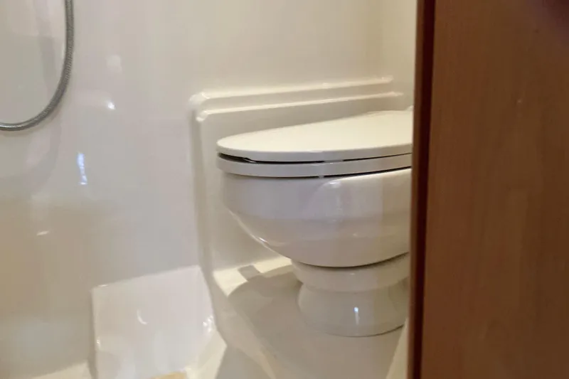 Slide: The Image of Bathroom interior of 2003 Regal Commodore 4260 yacht, featuring a compact toilet. - 59