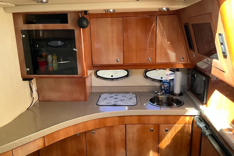 Slide: The Image of 2003 Regal Commodore 4260 yacht kitchen with wooden cabinets and modern amenities. - 62