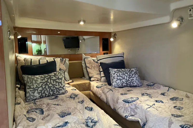 Slide: The Image of 2003 Regal Commodore 4260 cabin with twin beds, nautical-themed bedding, and cozy lighting. - 65