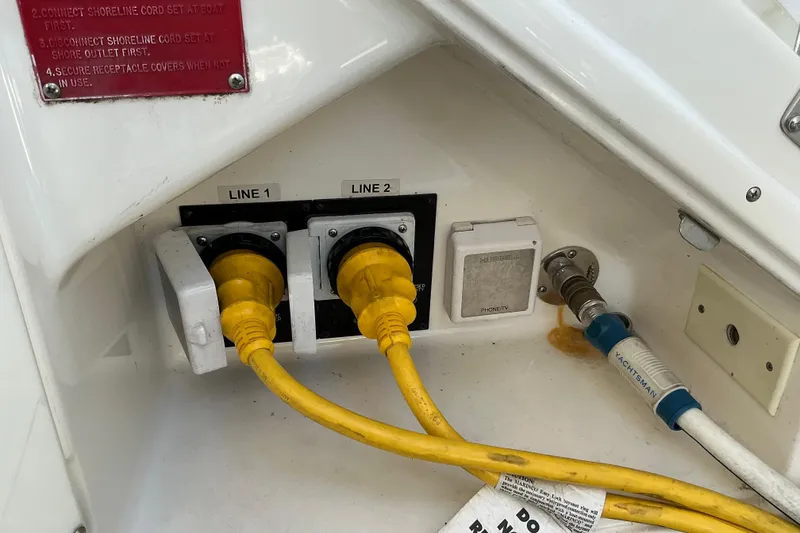 Slide: The Image of 2003 Regal Commodore 4260 boat power connections with yellow cables and water hose. - 71