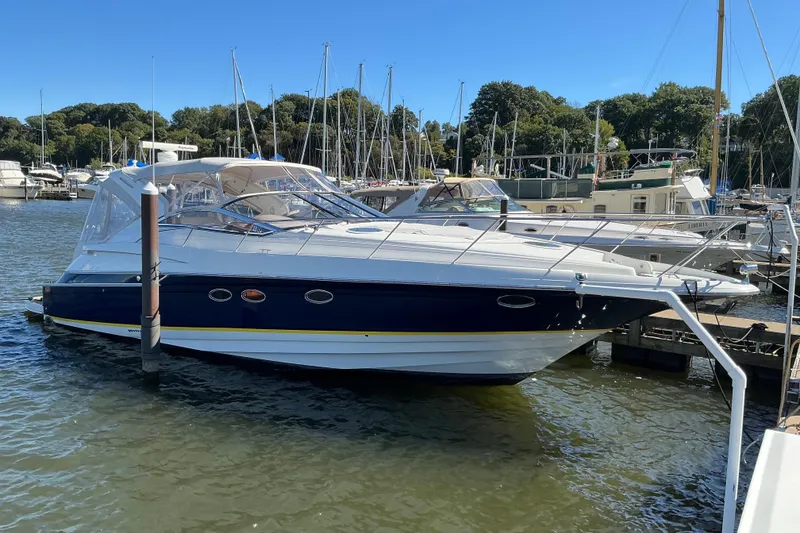 The Image of 2003 Regal Commodore 4260 yacht docked at marina under clear blue sky. - 8