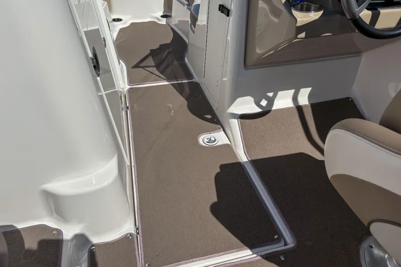 Slide: The Image of 2013 Yamaha SX240 HO boat interior with brown carpet and seating area. - 10
