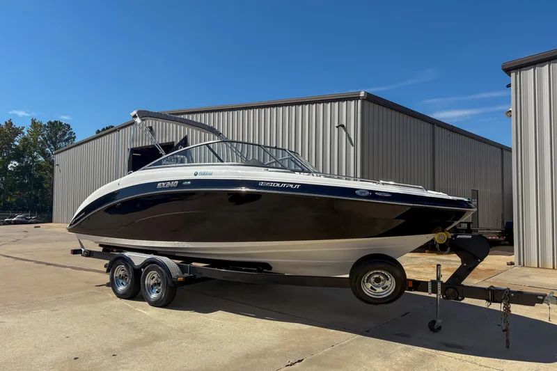 Slide: The Image of 2013 Yamaha SX240 HO boat on trailer, parked outside industrial building. - 3