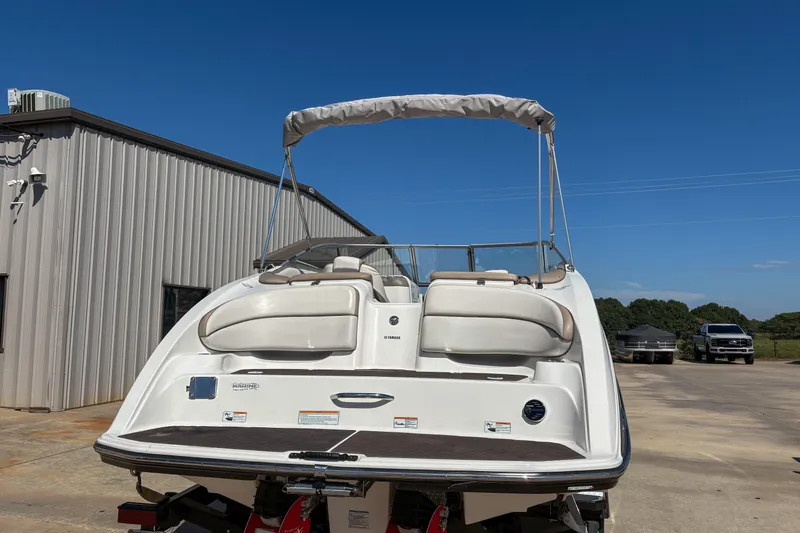 Slide: The Image of 2013 Yamaha SX240 HO boat with bimini top, parked outdoors on a sunny day. - 4