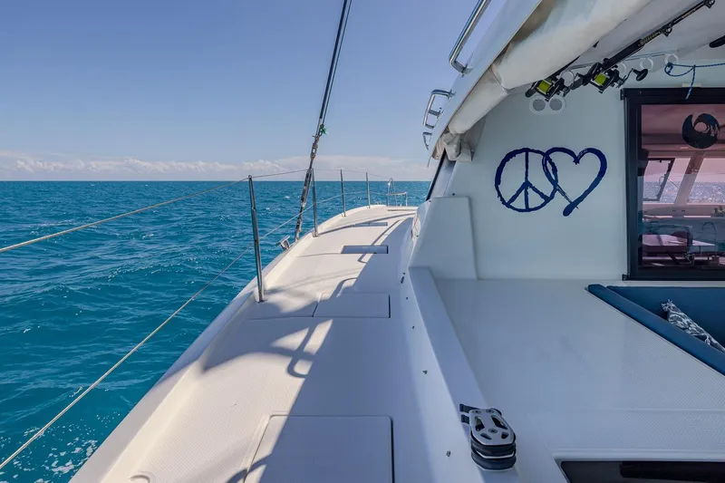 Slide: The Image of 2020 Fountaine Pajot Saona 47 sailing on clear blue ocean, peace and heart symbols visible. - 35