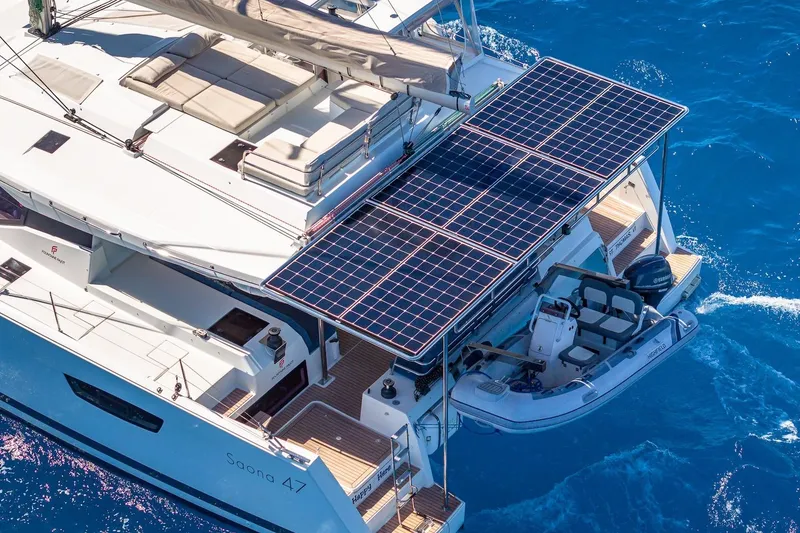 Slide: The Image of 2020 Fountaine Pajot Saona 47 catamaran with solar panels and tender on blue ocean. - 38