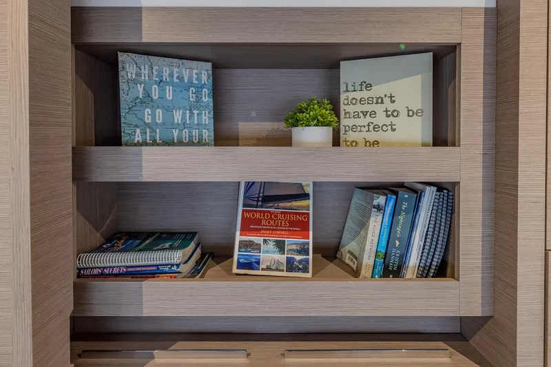 Slide: The Image of Bookshelf on Fountaine Pajot Saona 47 yacht, featuring travel books and decor. - 58