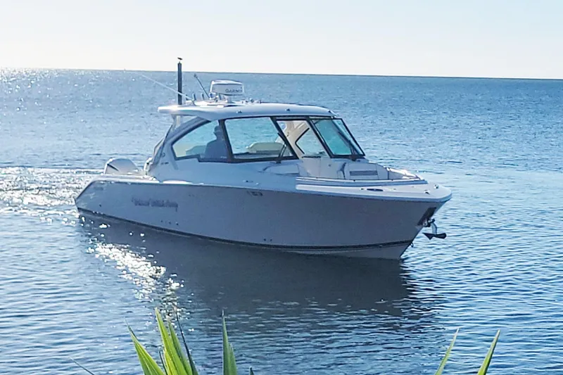 Slide: The Image of 2021 Pursuit DC 326 Dual Console boat cruising on calm ocean waters. - 1