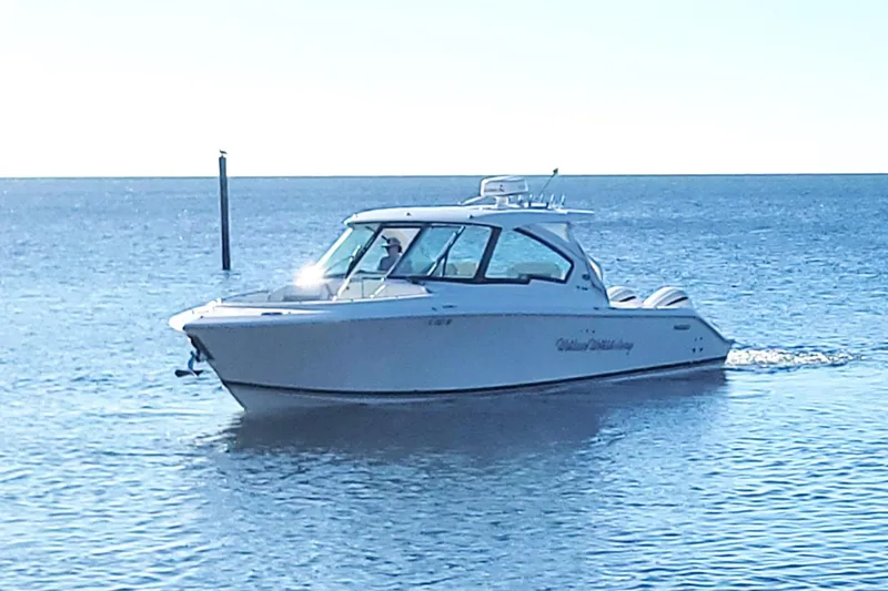 Slide: The Image of 2021 Pursuit DC 326 Dual Console boat cruising on calm blue waters. - 3
