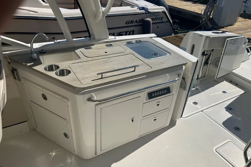 Slide: The Image of 2018 Boston Whaler 320 Vantage boat interior with sink and storage area. - 13