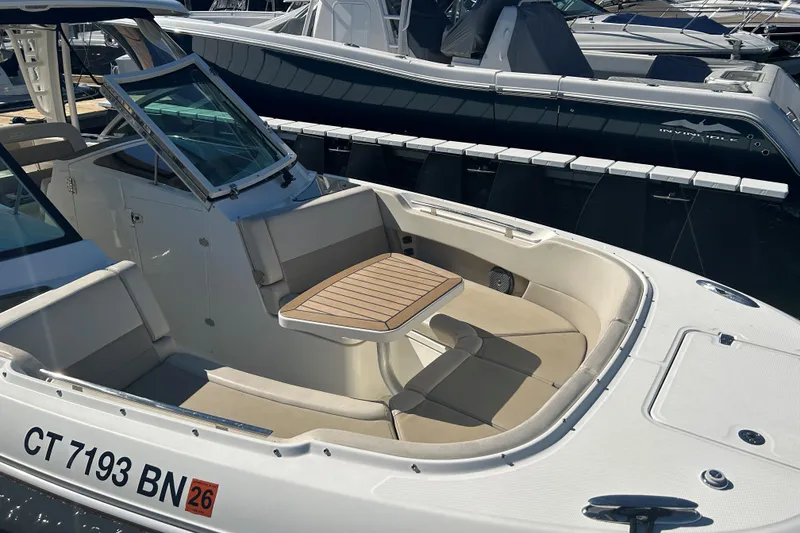 Slide: The Image of 2018 Boston Whaler 320 Vantage boat with seating and table, docked at marina. - 16