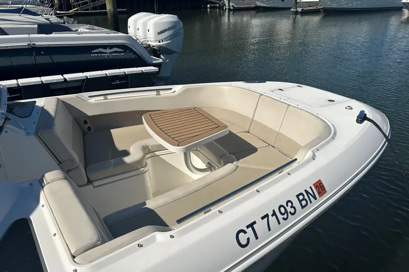 Slide: The Image of 2018 Boston Whaler 320 Vantage boat with seating and table, docked in marina. - 17