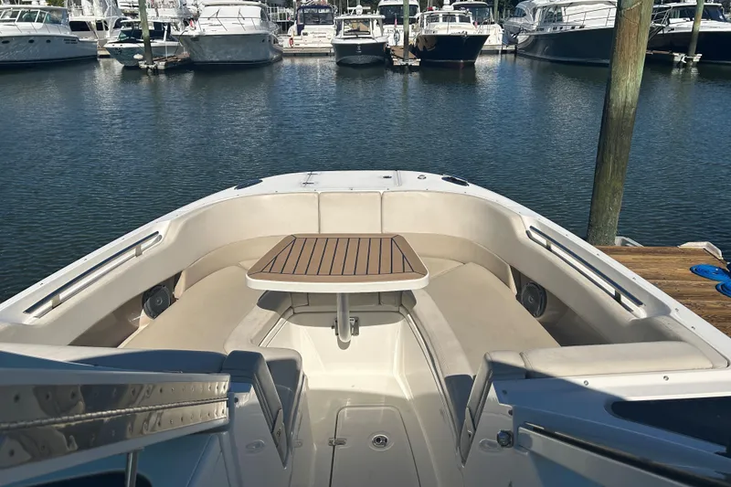 Slide: The Image of 2018 Boston Whaler 320 Vantage boat interior with seating and table at marina. - 18