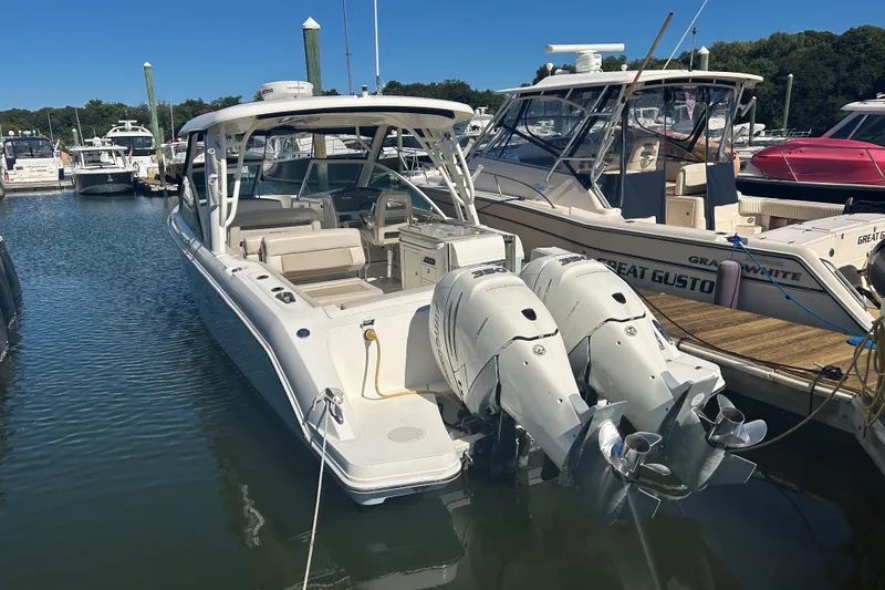 Slide: The Image of 2018 Boston Whaler 320 Vantage docked with twin outboard engines. - 2