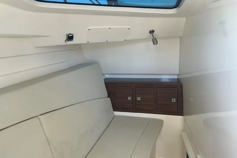 Slide: The Image of 2018 Boston Whaler 320 Vantage cabin interior with seating and storage cabinets. - 23
