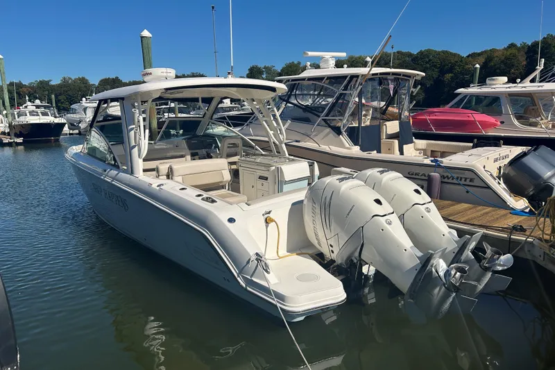 Slide: The Image of 2018 Boston Whaler 320 Vantage docked with twin engines, clear sky background. - 3