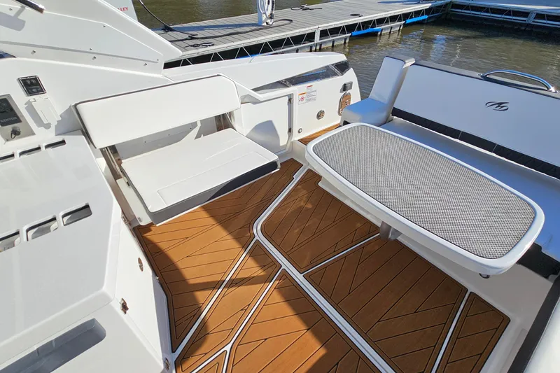 Slide: The Image of 2022 Monterey 378SS Super Sport boat interior with seating and table, dockside view. - 10