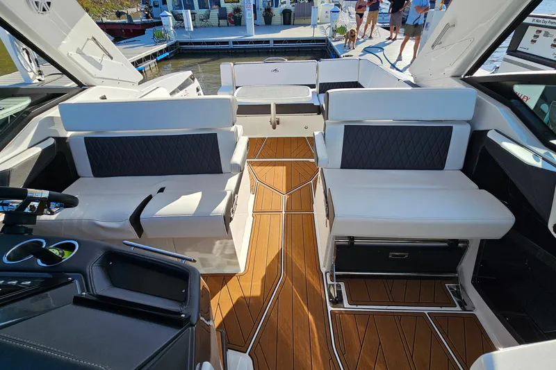 Slide: The Image of 2022 Monterey 378SS Super Sport boat interior with luxurious seating and wooden flooring. - 12