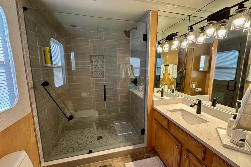 Slide: The Image of Luxurious bathroom in 2003 Sumerset 18x80 houseboat with glass shower and dual sinks. - 12