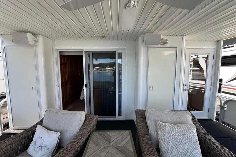 Slide: The Image of 2003 Sumerset 18x80 houseboat interior with wicker seating and sliding glass doors. - 13