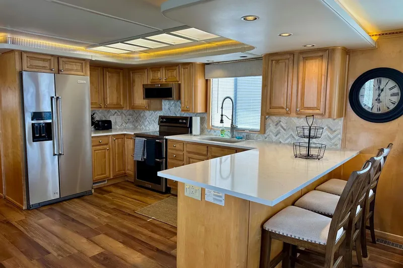 Slide: The Image of Modern kitchen in a 2003 Sumerset 18x80 houseboat with wood cabinets and stainless steel appliances. - 4