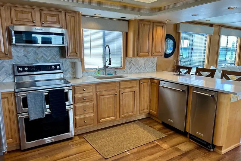 Slide: The Image of Modern kitchen in a 2003 Sumerset 18x80 houseboat with wood cabinets and stainless steel appliances. - 5
