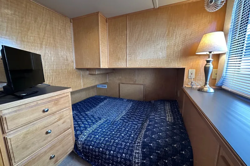 Slide: The Image of Cozy bedroom in 2003 Sumerset 18x80 houseboat with TV, lamp, and blue bedding. - 8
