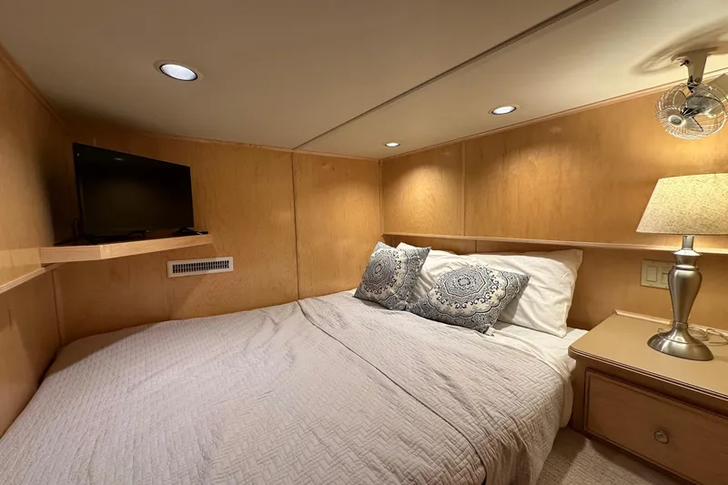 Slide: The Image of Cozy bedroom in 2003 Sumerset 18x80 houseboat with TV, lamp, and decorative pillows. - 9