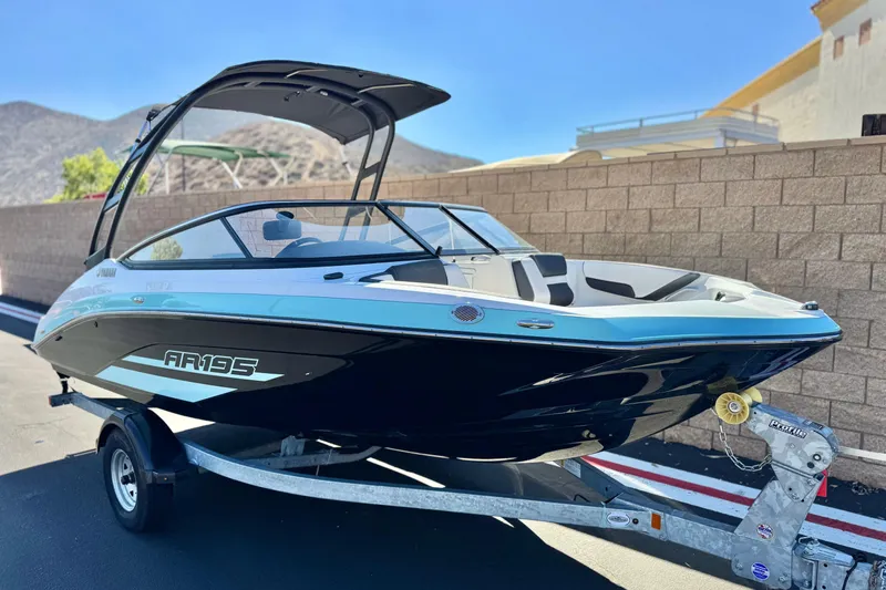 Slide: The Image of 2023 Yamaha Boats AR195 on trailer, sleek design, black and white exterior. - 1
