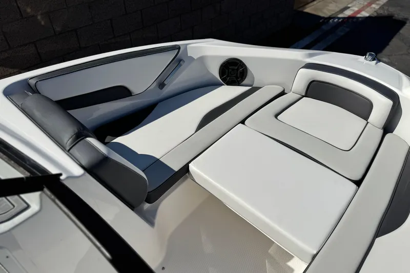 Slide: The Image of 2023 Yamaha Boats AR195 interior with sleek, modern seating and integrated speaker system. - 13