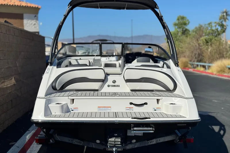 Slide: The Image of 2023 Yamaha Boats AR195, rear view, parked outdoors on a sunny day. - 4